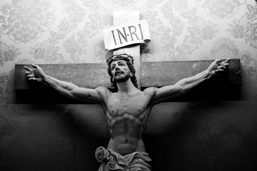 Kříž za hradbami a dva nápisy na něm